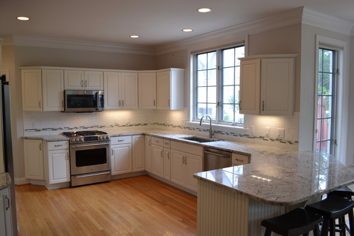 White Ice Granite with Alabaster White Cabinets and Bliss 1 Iceland Linear Mosaic with Stainless Steel Appliance and Red Oak Flooring